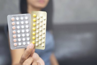 jonge vrouw houdt geboortebeperking pillengenç kadın doğum kontrol hapları tutar
