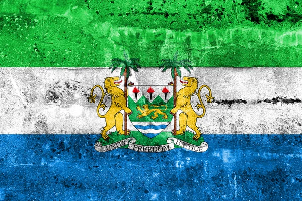 Flagge von Sierra Leone mit Wappen, an schmutzige Wand gemalt — Stockfoto