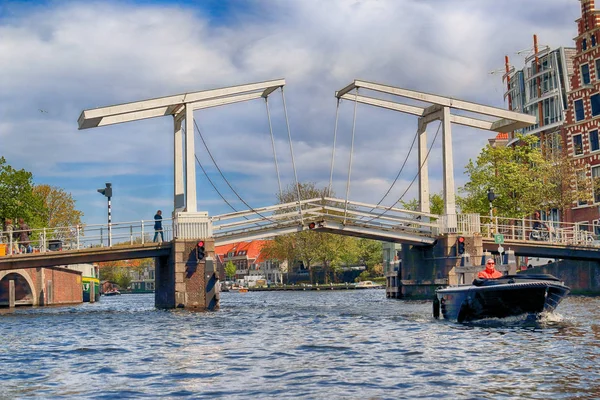 Haarlem, Nizozemsko - 30 duben 2017: Gravestenen padací most přes řeku Spaarne. Typické holandské architektury. Pohled z úrovně lodí. — Stock fotografie