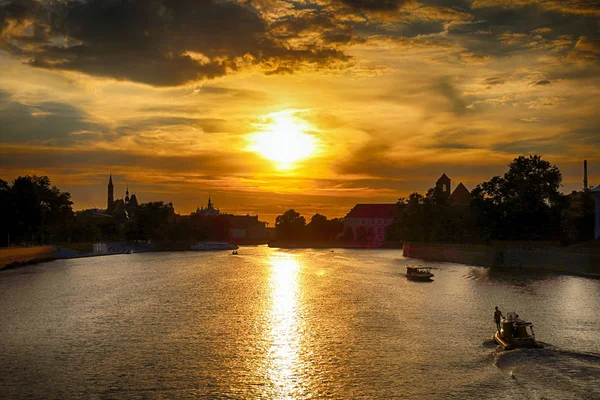 WROCLAW, POLOGNE - 8 AOÛT 2017 : La vieille ville de Wroclaw. Cathedral Island (Ostrow Tumski) est la partie la plus ancienne de la ville. Rivière Odra, bateaux et bâtiments historiques pendant le magnifique coucher de soleil . — Photo