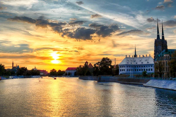 WROCLAW, POLONIA - 8 de agosto de 2017: Ciudad Vieja de Wroclaw. La Isla Catedral (Ostrow Tumski) es la parte más antigua de la ciudad. Río Odra, barcos y edificios históricos durante el hermoso atardecer . — Foto de Stock