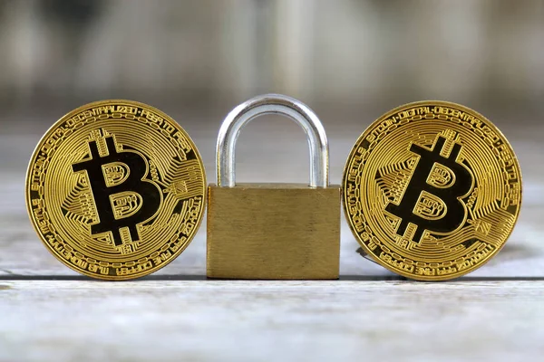 Versión física de Bitcoin (nuevo dinero virtual) y candado de oro. Imagen conceptual para el dinero y la seguridad criptomoneda . — Foto de Stock