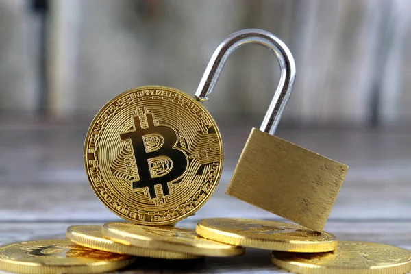 Versión física de Bitcoin (nuevo dinero virtual) y candado de oro. Imagen conceptual para el dinero y la seguridad criptomoneda . — Foto de Stock