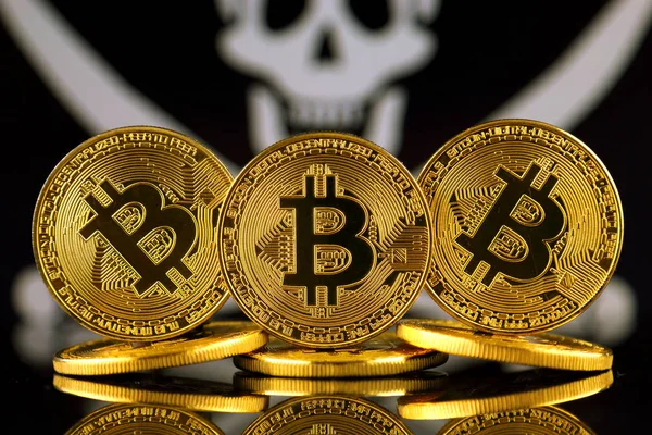 Physical version of Bitcoin (new virtual money) and Pirate Flag. Conceptual image for investors in cryptocurrency and Blockchain Technology. Risk, safety and security. — Stock Photo, Image