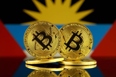 Fiziksel sürüm Bitcoin ve Antigua ve Barbuda bayrağı. Yakın çekim.