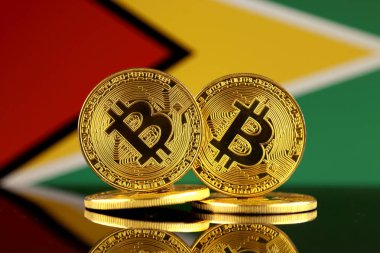 Bitcoin ve Guyana bayrak fiziksel sürümü. Yakın çekim.