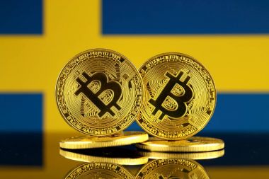 Bitcoin ve İsveç bayrağı fiziksel sürümü. Yakın çekim.