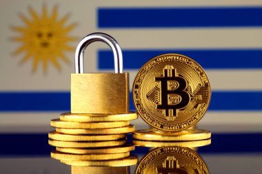 Bitcoin, altın asma kilit ve Uruguay bayrağı fiziksel sürümü. Cryptocurrencies, yönetmelikler, kısıtlamaları veya güvenlik, koruma, gizlilik yasaklanması.