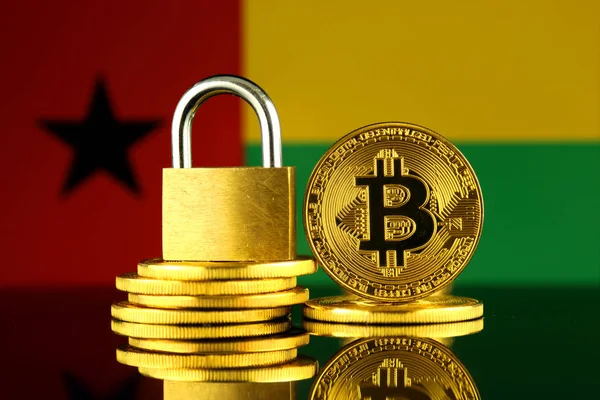 Bitcoin, altın asma kilit ve Gine Bissau bayrağı fiziksel sürümü. Cryptocurrencies, yönetmelikler, kısıtlamaları veya güvenlik, koruma, gizlilik yasaklanması.