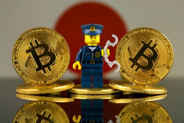 Wroclaw, Polonya - 10 Mart 2018: Bitcoin, polis memuru (olarak Lego rakam) ve Japonya bayrağı fiziksel sürümü. Stüdyo vurdu.