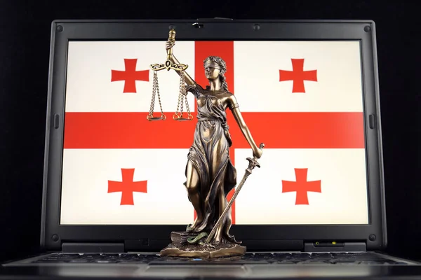 Symbol of law and justice with Georgia Flag on laptop. Studio shot.