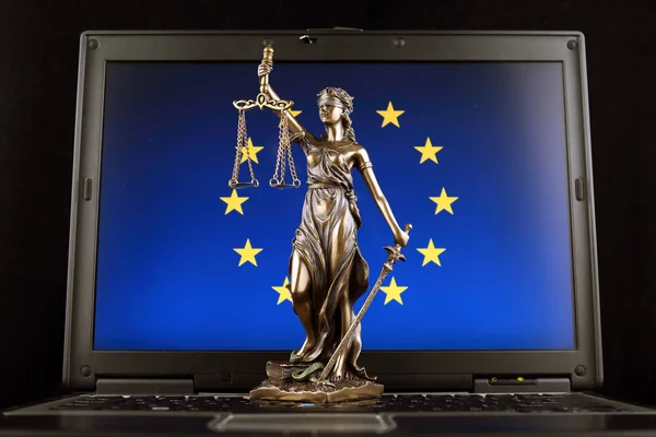Symbol of law and justice with European Union Flag on laptop. Studio shot.