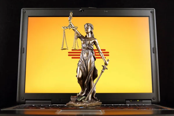 Symbol of law and justice with New Mexico State Flag on laptop. Studio shot.