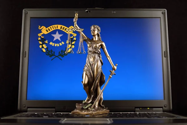 Symbol of law and justice with Nevada State Flag on laptop. Studio shot.