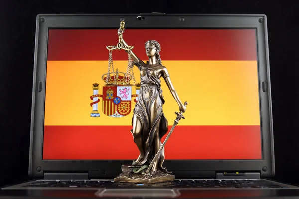 法とスペイン フラグ付きのラップトップ上の正義の象徴 スタジオ撮影 — ストック写真