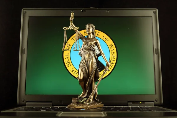 Symbol of law and justice with Washington State Flag on laptop. Studio shot.