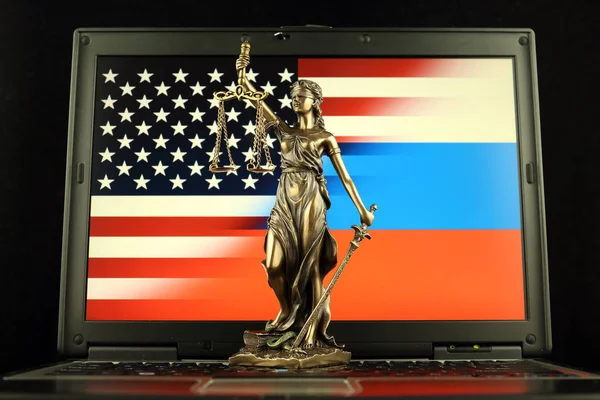 Symbol of law and justice with United States and Russia Flag on laptop. Studio shot.