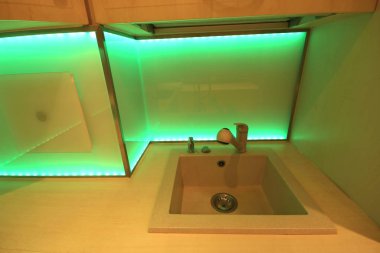 Wroclaw, Polonya - 17 Kasım 2019: Özel döşeli modern lüks mutfak ve Led Rgb arka aydınlatma camı. Wroclaw, Polonya 'da özel bir dairede..