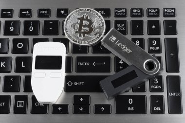 Wroclaw, Polonya - 28 Ocak 2020: Bitcoin (Btc), Trezor ve Ledger (şifreli para birimi donanım cüzdanları) ve siyah dizüstü bilgisayarlı klavyenin fiziksel versiyonu.