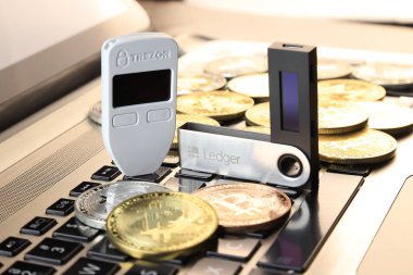 Wroclaw, Polonya - 28 Ocak 2020: Bitcoin (Btc), Trezor ve Ledger (şifreli para birimi donanım cüzdanları) ve siyah dizüstü bilgisayarlı klavyenin fiziksel versiyonu.