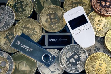 Wroclaw, Polonya - 28 Ocak 2020: Bitcoin (Btc), Trezor ve Ledger 'ın fiziksel versiyonu (kripto para birimi donanım cüzdanları) ve düğmeye basın.