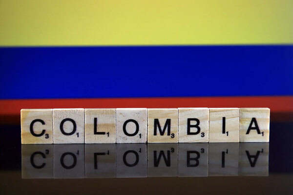 Colombia Flag and country name made of small wooden letters. Studio shot.