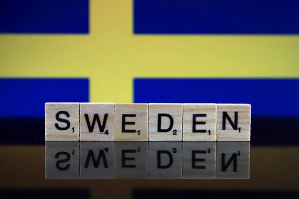 Sweden Flag and country name made of small wooden letters. Studio shot.
