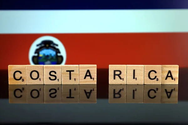 Costa Rica Flag and country name made of small wooden letters. Studio shot.