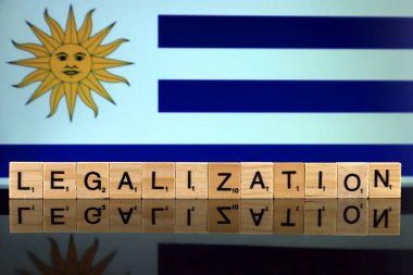 Wroclaw, Polonya - 4 Şubat 2020: Uruguay Bayrağı ve küçük tahta harflerden yapılmış kelime yasallaştırma. Uyuşturucu politikası. Esrarın yasallaştırılması.