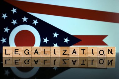 Wroclaw, Polonya - 4 Şubat 2020 Ohio Eyalet Bayrağı ve küçük ahşap harflerden yapılmış kelime yasallaştırma. Uyuşturucu politikası. Esrarın yasallaştırılması.