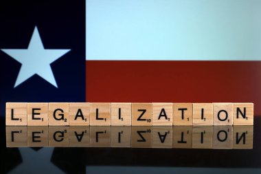 Wroclaw, Polonya - 4 Şubat 2020: Texas Eyalet Bayrağı ve küçük tahta harflerden yapılmış kelime yasallaştırma. Uyuşturucu politikası. Esrarın yasallaştırılması.