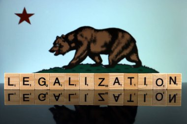 Wroclaw, Polonya - 4 Şubat 2020: Kaliforniya Eyalet Bayrağı ve küçük tahta harflerden yapılmış kelime yasallaştırma. Uyuşturucu politikası. Esrarın yasallaştırılması.
