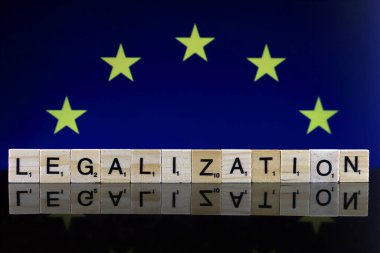 Wroclaw, Polonya - 4 Şubat 2020: Avrupa Birliği Bayrağı ve küçük tahta harflerden oluşan kelime yasallaştırması. Uyuşturucu politikası. Esrarın yasallaştırılması.