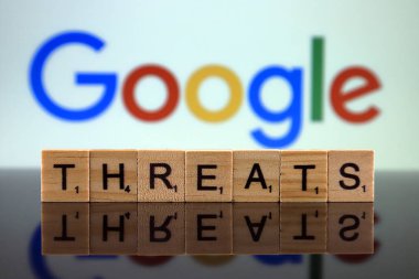 Wroclaw, Polonya - 12 Şubat 2020: Küçük tahta harflerden yapılmış kelime tehditleri ve arka planda Google logosu. Stüdyo çekimi.