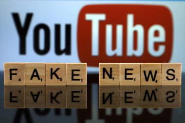 Wroclaw, Polonya - 12 Şubat 2020: Arka planda küçük tahta harflerden yapılmış Kelimeler Sahte Haberler ve Youtube logosu. Stüdyo çekimi.