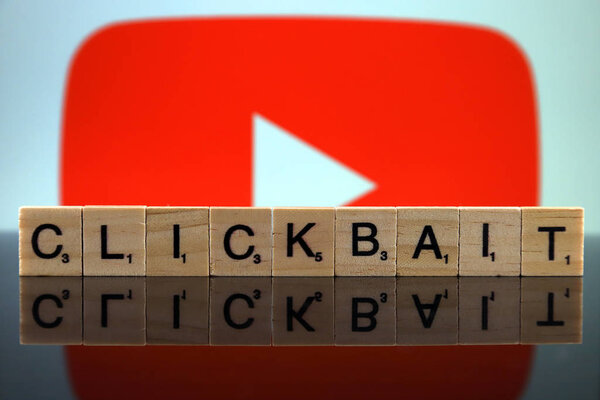 WROCLAW, POLAND - FEBRUARY 12, 2020: Word CLICKBAIT made of small wooden letters, and YOUTUBE logo in the background. Studio shot.