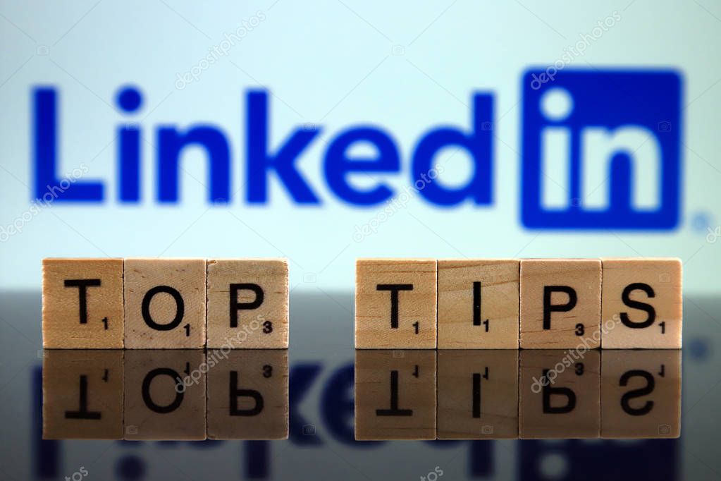WROCLAW, POLAND - FEBRUARY 12, 2020: Words TOP TIPS made of small wooden letters, and LINKEDIN logo in the background. Studio shot.