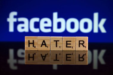 Wroclaw, Polonya - 12 Şubat 2020: Kelime düşmanı arka planda küçük tahta harflerden ve Facebook logosundan yapılmış. Stüdyo çekimi.