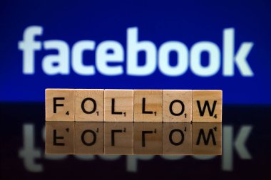 Wroclaw, Polonya - 12 Şubat 2020: Küçük tahta harflerden oluşan Word Follow ve arka planda Facebook logosu. Stüdyo çekimi.