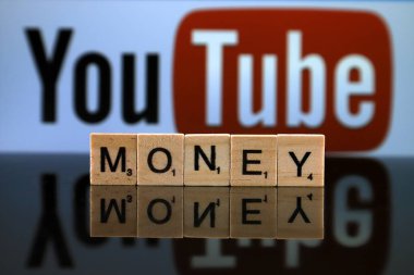 Wroclaw, Polonya - 12 Şubat 2020: Küçük tahta harflerden yapılmış Word Money ve arka planda Youtube logosu. Stüdyo çekimi.