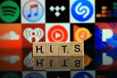 WROCLAW, POLAND - FEBRUARY 19, 2020: Word HITS made of wooden letters, and SPOTIFY, ITUNES, TIDAL, SHAZAM, DEEZER, SOUNDCLOUD, IHEART RADIO, YOUTUBE MUSIC, GOOGLE PLAY MUSIC, PANDORA logos.