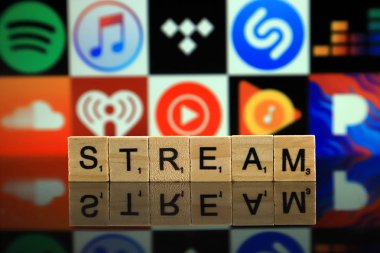 WROCLAW, POLAND - FEBRUARY 19, 2020: Word STREAM made of wooden letters, and SPOTIFY, ITUNES, TIDAL, SHAZAM, DEEZER, SOUNDCLOUD, IHEART RADIO, YOUTUBE MUSIC, GOOGLE PLAY MUSIC, PANDORA logos.