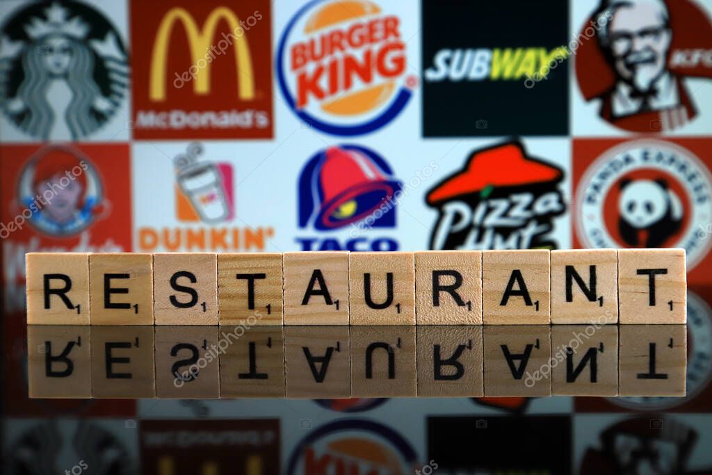 WROCLAW, POLAND - FEBRUARY 19, 2020: Word RESTAURANT made of wooden letters, and STARBUCKS, McDONALDS, BURGER KING, SUBWAY, KFC, WENDY'S, DUNKIN DONUTS, TACO BELL, PIZZA HUT, PANDA EXPRESS logos.