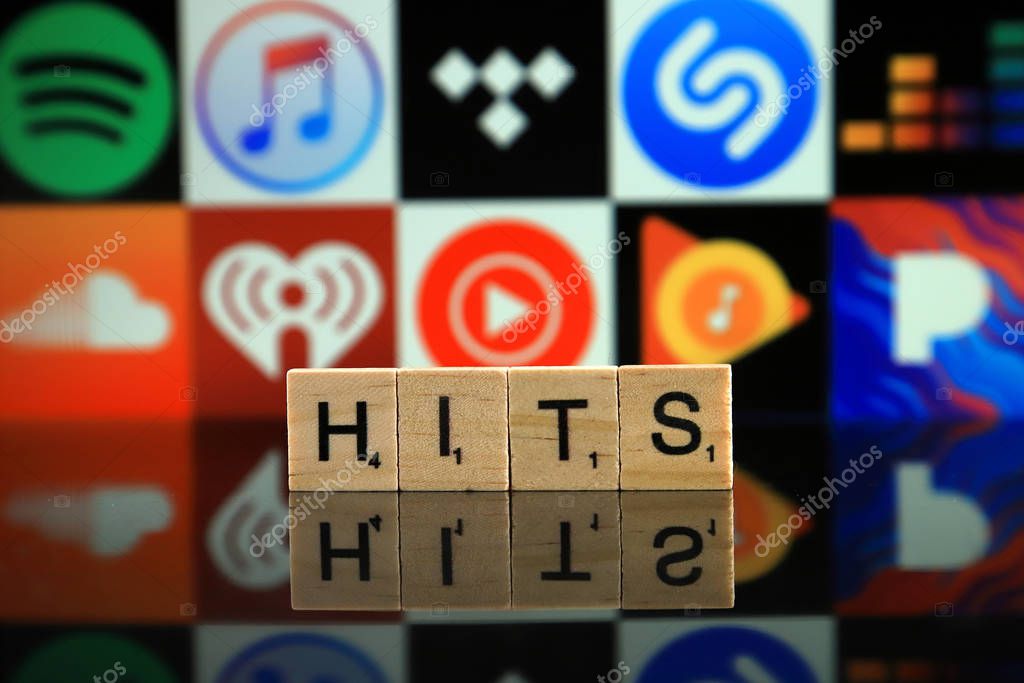 WROCLAW, POLAND - FEBRUARY 19, 2020: Word HITS made of wooden letters, and SPOTIFY, ITUNES, TIDAL, SHAZAM, DEEZER, SOUNDCLOUD, IHEART RADIO, YOUTUBE MUSIC, GOOGLE PLAY MUSIC, PANDORA logos.
