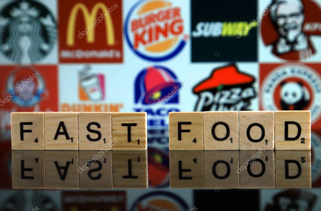WROCLAW, POLAND - FEBRUARY 19, 2020: Words FAST FOOD made of wooden letters, and STARBUCKS, McDONALDS, BURGER KING, SUBWAY, KFC, WENDY'S, DUNKIN DONUTS, TACO BELL, PIZZA HUT, PANDA EXPRESS logos.