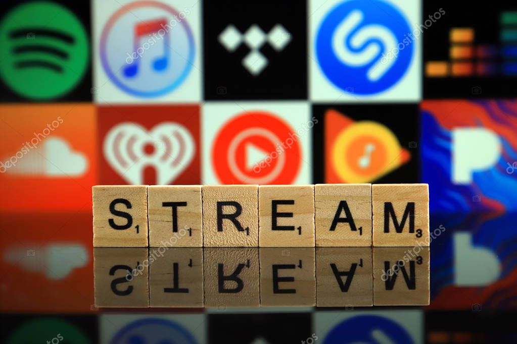 WROCLAW, POLAND - FEBRUARY 19, 2020: Word STREAM made of wooden letters, and SPOTIFY, ITUNES, TIDAL, SHAZAM, DEEZER, SOUNDCLOUD, IHEART RADIO, YOUTUBE MUSIC, GOOGLE PLAY MUSIC, PANDORA logos.