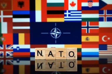 Wroclaw, Polonya - 19 Şubat 2020: Arkaplanda üye ülkelerin bayrakları bulunan Nato bayrağı (Kuzey Atlantik Anlaşması Örgütü) ve tahta harflerden oluşan kelime.