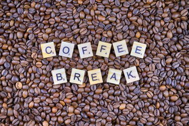 Wroclaw, Polonya - 25 Şubat 2020: Scrabble harflerinden yapılmış Kelimeler Kahve Molası ve arka planda kahve taneleri. Lezzetli kahve severler için kavramsal imaj.