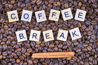 Wroclaw, Polonya - 25 Şubat 2020: Tarçın çubuklu Scrabble harflerinden yapılmış Kelimeler Kahve Molası ve arka planda kahve taneleri. Lezzetli kahve severler için kavramsal imaj.