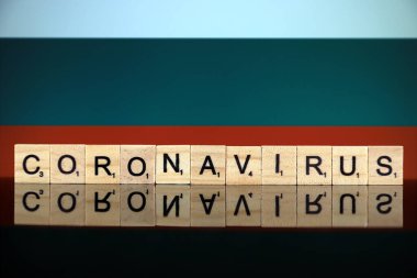 WROCLAW, POLAND - 28 Mart 2020: Kelime CORONAVIRUS ahşap harflerden yapılmış ve arka planda Bulgaristan Bayrağı. Coronavirus (COVID-19) küresel hastalık 2020.